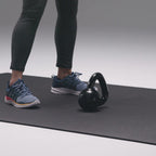 Running shoes and a kettlebell on the exercise mat