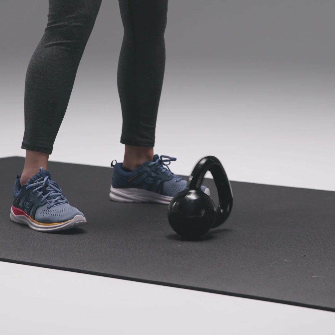 Running shoes and a kettlebell on the exercise mat