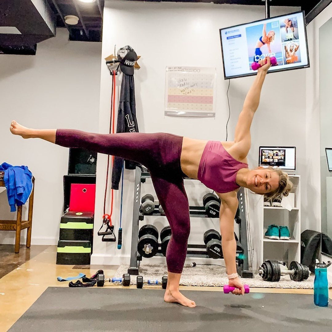 Woman in a half moon balance with a dumbbell on a large Silverback Gray exercise mat