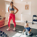 Mom in sneakers with her son on a large black exercise mat