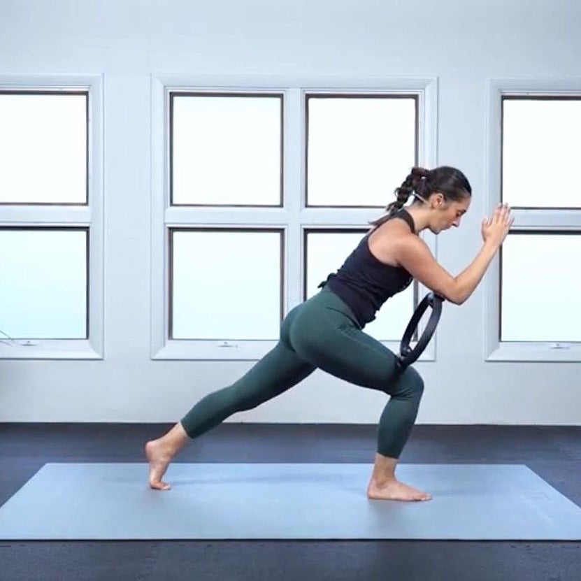 Woman in a lunge with a resistance ring on a large Silverback Gray exercise mat