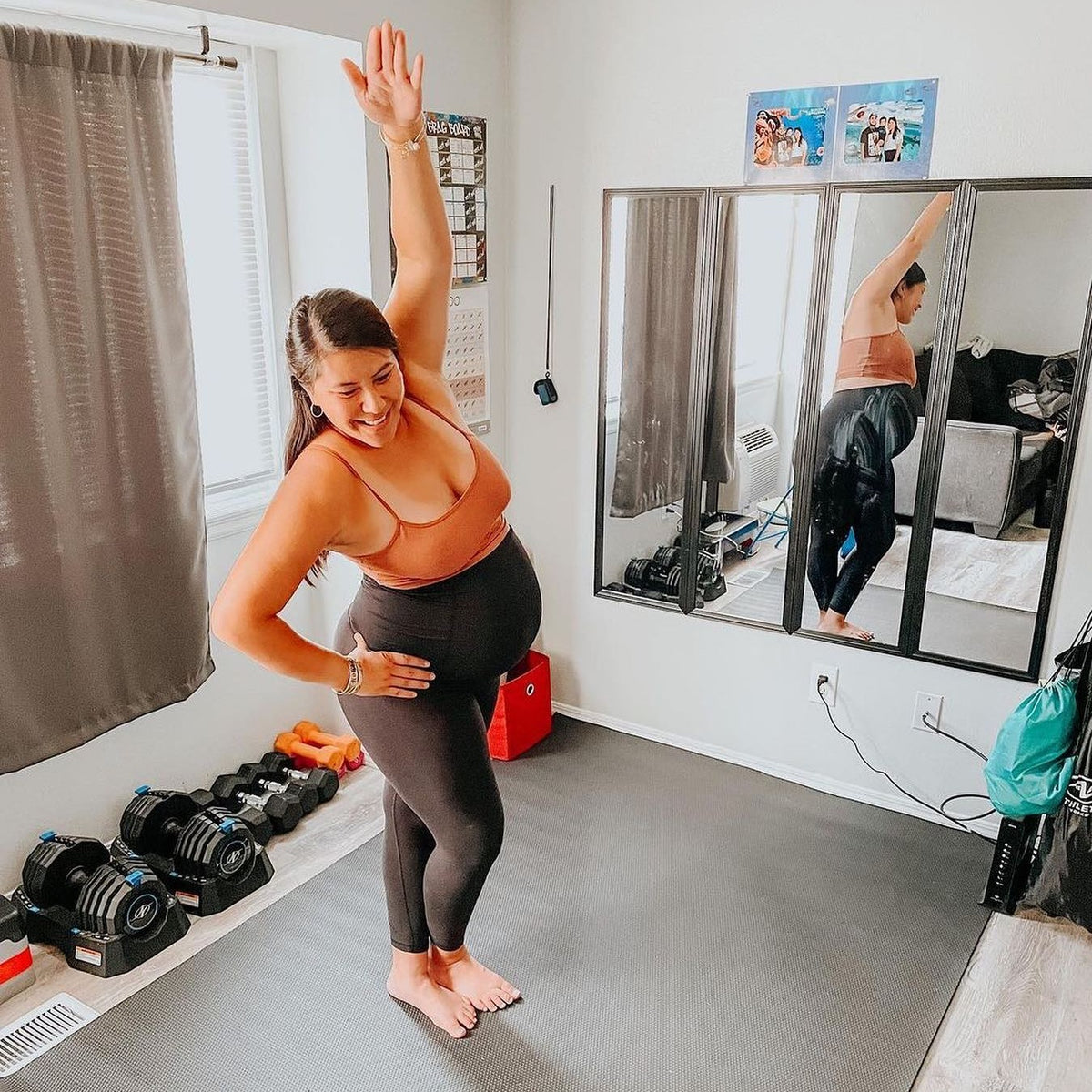 Pregnant woman stretching on a large Silverback Gray exercise mat in her home gym