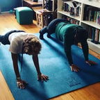 Two women doing push-ups side by side on a large Oasis Blue yoga mat