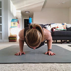 Woman doing a push-up on a large Silverback Gray exercise mat in her living room