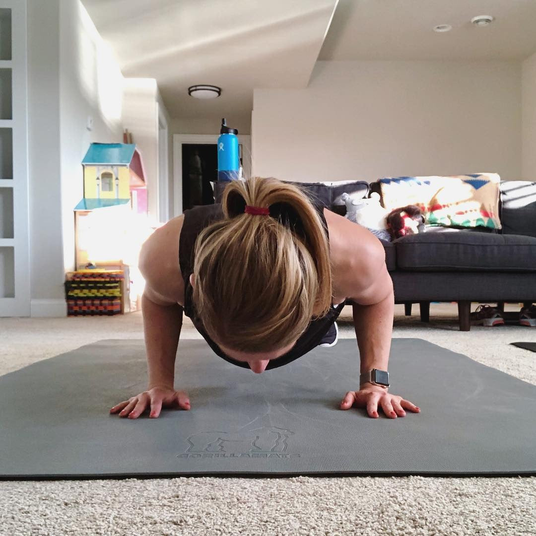 Woman doing a push-up on a large Silverback Gray exercise mat in her living room