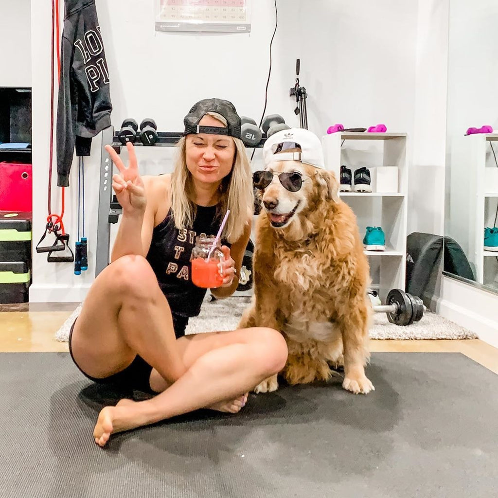 Woman sitting with her golden retriever on a large Silverback Gray exercise mat