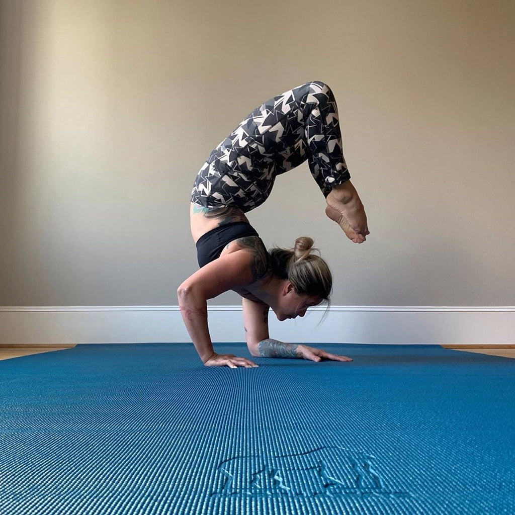 Woman in a scorpion arm balance on a large Oasis Blue yoga mat