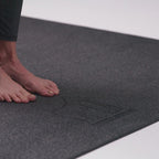 Bare feet on the textured top of the yoga mat