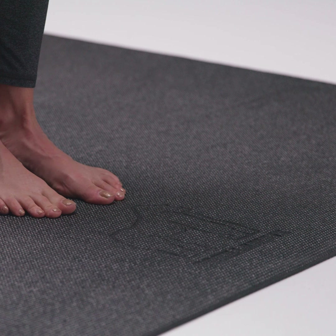 Bare feet on the textured top of the yoga mat