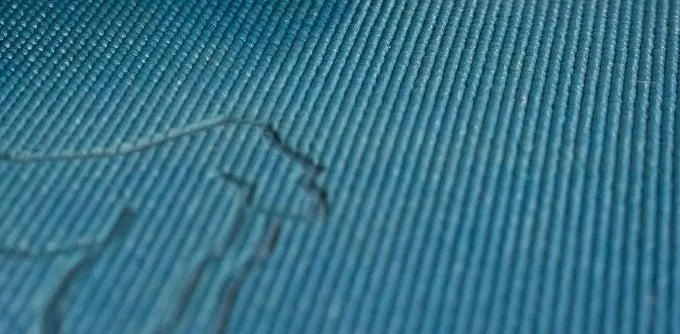Close-up of the teal yoga mat surface with the embossed gorilla